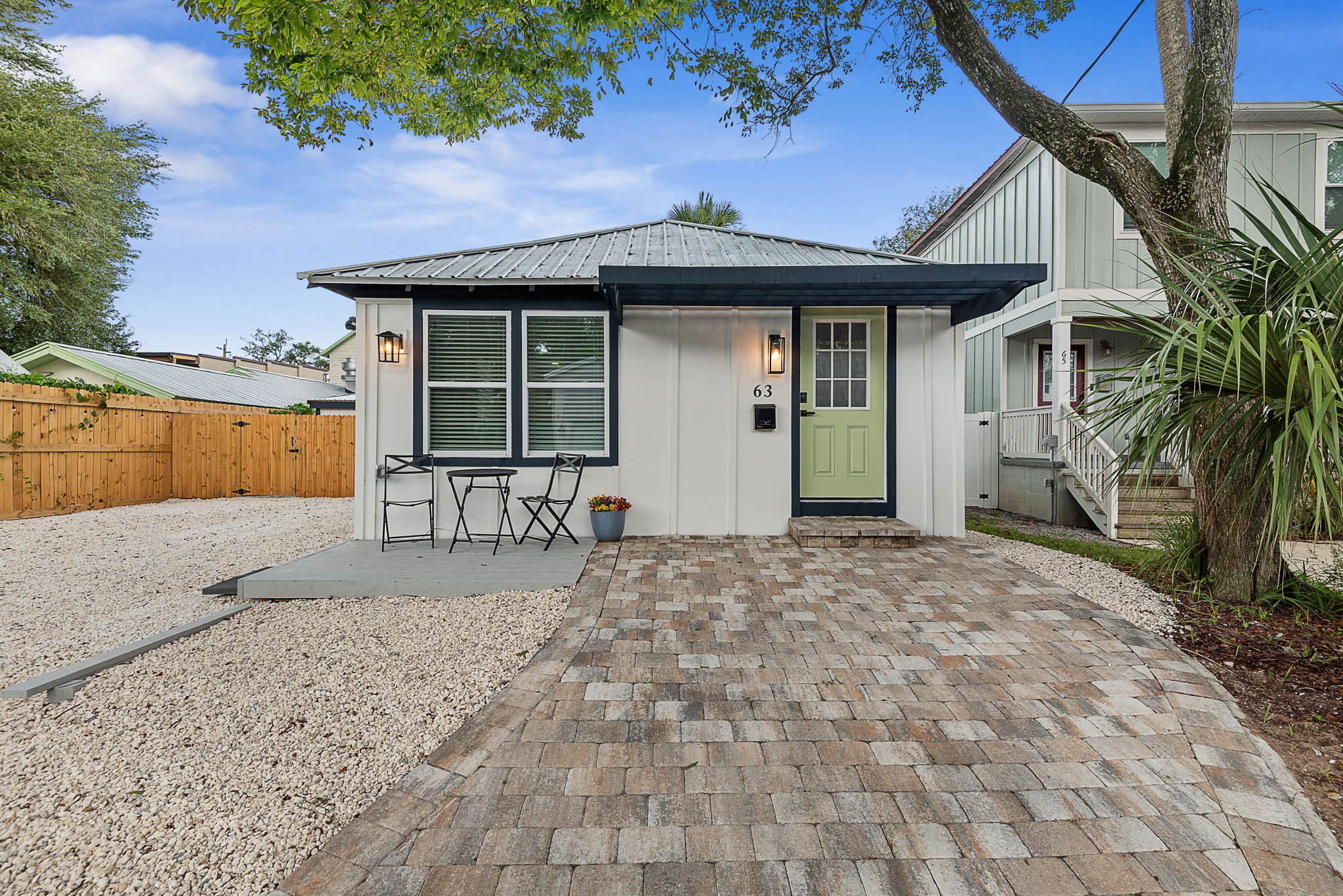 63 Oneida St exterior - restored 1925 cottage with green door and paver drive